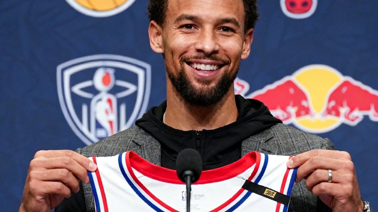 NBA转会新闻配图：一位全明星球员在新闻发布会上展示新球队球衣，背景是交易相关的两队标志